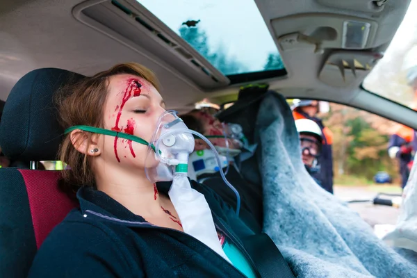 Acidente de carro - Vítima em veículo acidentado recebendo primeiros socorros — Fotografia de Stock