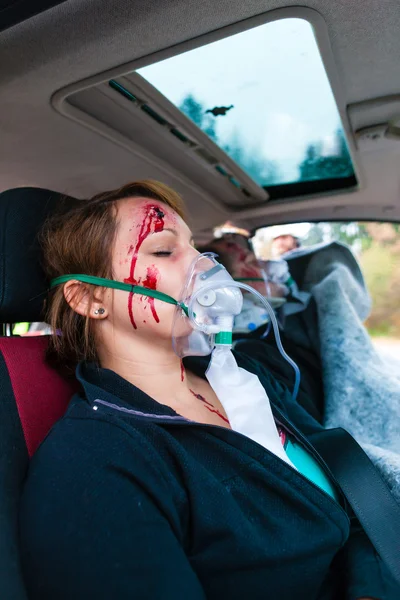 Car accident - Victim in crashed vehicle receiving first aid — Stock Photo, Image