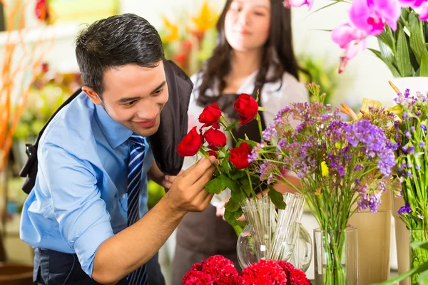 Prodavačka a zákazníka v květinářství — Stock fotografie
