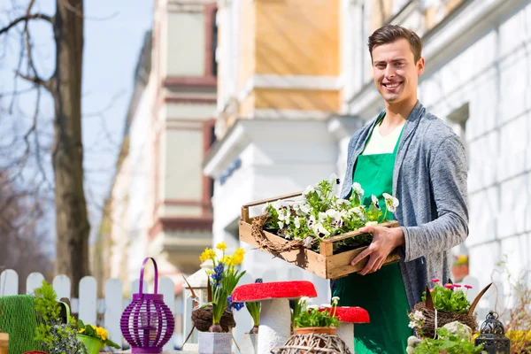 Florist mit Pflanzenversorgung im Geschäft — Stockfoto