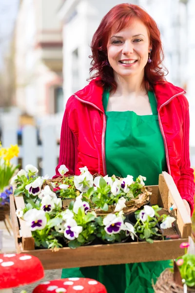 Floristin mit Pflanzen Lieferung vor Laden — Stock Fotó