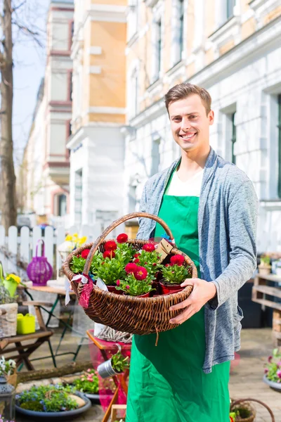 Fiorista con cesto di fiori in negozio di vendita — Foto Stock