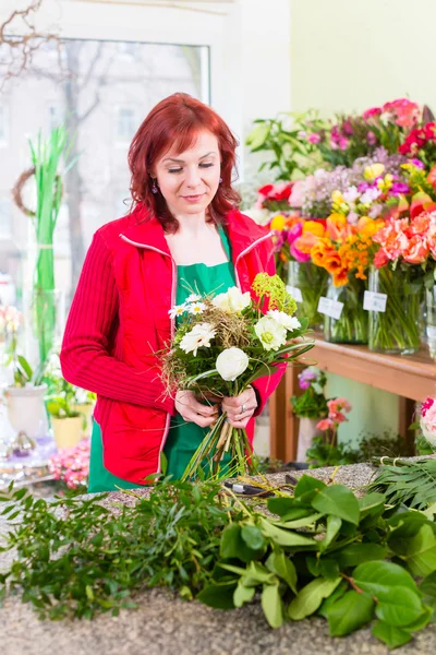 Blumengeschäft bindet Blumenstrauß im Geschäft — Stockfoto