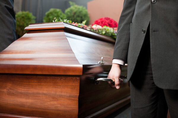 coffin bearer carrying casket at funeral