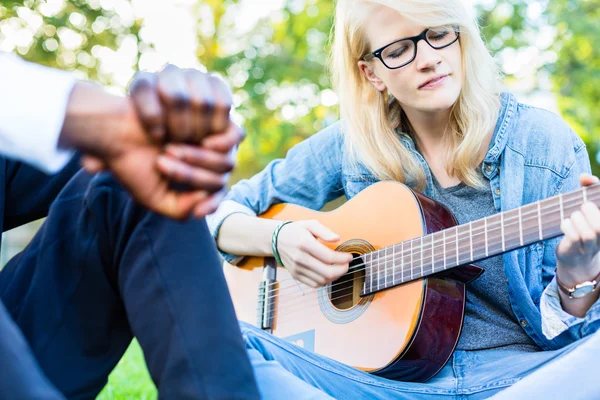 Amici che cantano canzoni nel parco divertendosi insieme — Foto Stock