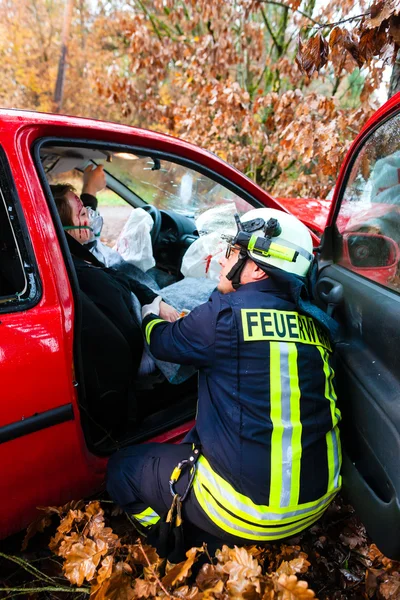 Les pompiers secourent la victime d'un accident de voiture — Photo