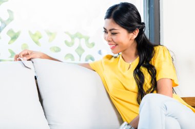 Asyalı kadın kanepe içinde stok ve fiyat kontrol