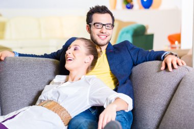 Couple buying couch in furniture store clipart