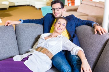 Couple buying couch in furniture store clipart
