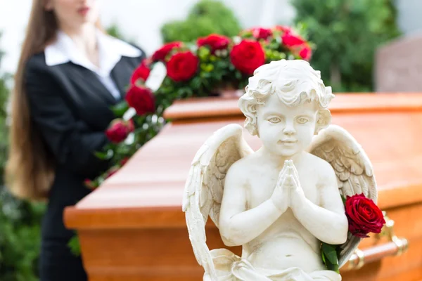 Траурная женщина на похоронах с гробом — стоковое фото