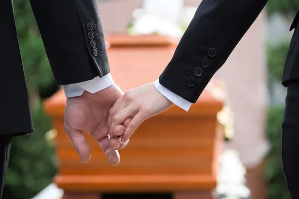 Люди на похоронах утешают друг друга — стоковое фото