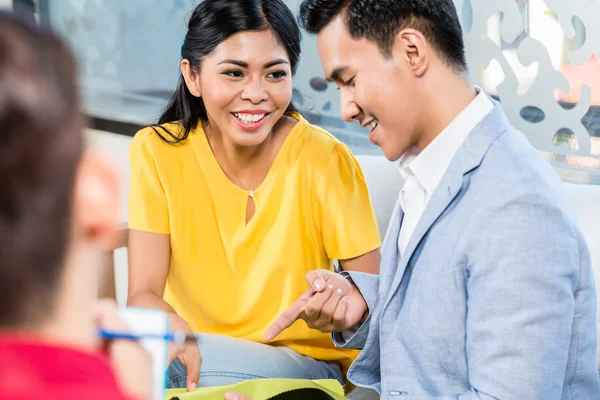 Couple with shop assistant in furniture store — Stock Photo, Image