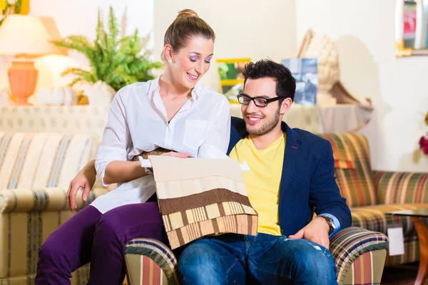 Pareja recogiendo sillón asiento cubierta en tienda de muebles —  Fotos de Stock