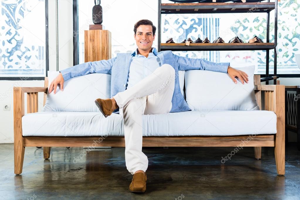 Man sitting on couch in furniture store showroom