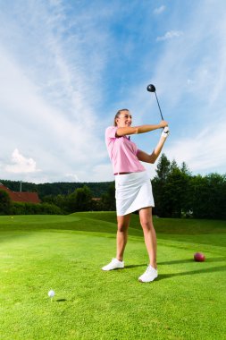 Genç kadın golf oyuncu sahasında golf salıncak yapmak