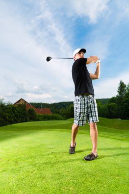 Genç golf oyuncu sahasında golf salıncak yapmak