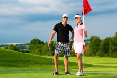 Bir Kursunda Golf oynayan genç sportif Çift