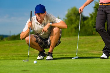 Young sportive couple playing golf on a course clipart