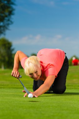Genç kadın golf oyuncu koymak için amaçlayan kurs
