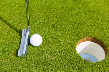 Golf oyuncu topu deliğe koyarak