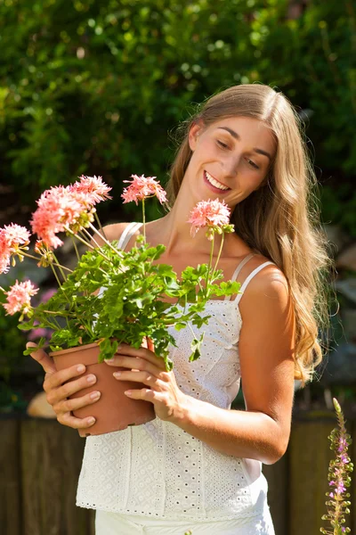 Tuin in de zomer - gelukkig vrouw met bloemen — Stockfoto