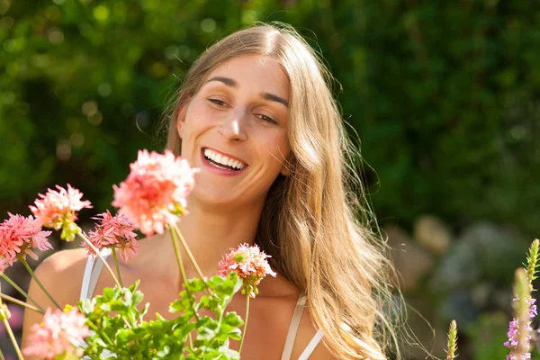 Garden in summer - happy woman with flowers — Stock Photo, Image