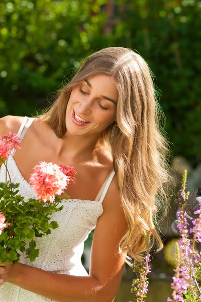 Trädgård i sommar - glad kvinna med blommor — Stockfoto