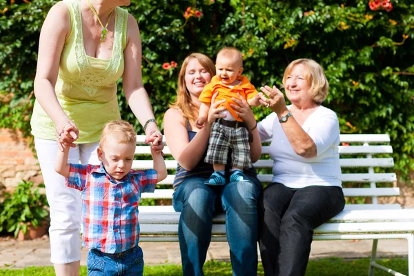 Two mothers with grandmother and children in park — Stock Fotó