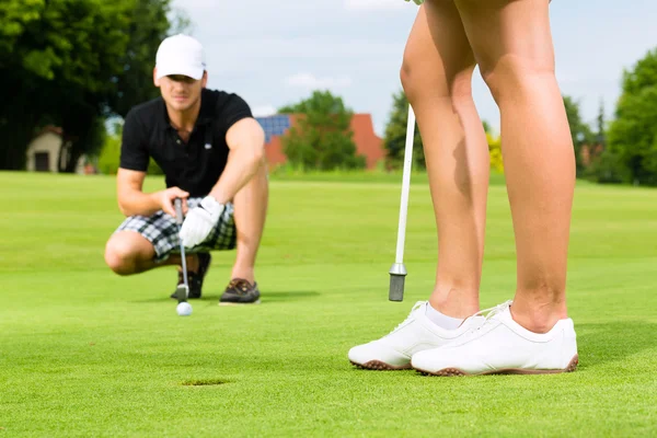 Jonge sportieve paar golfen op een cursus — Stockfoto