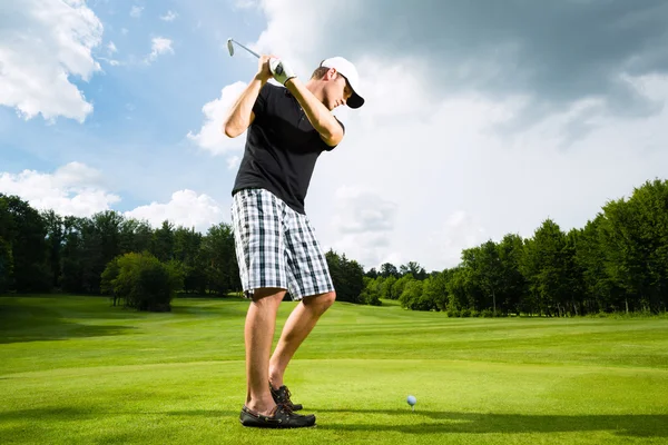 Jovem jogador de golfe em curso fazendo balanço de golfe — Fotografia de Stock