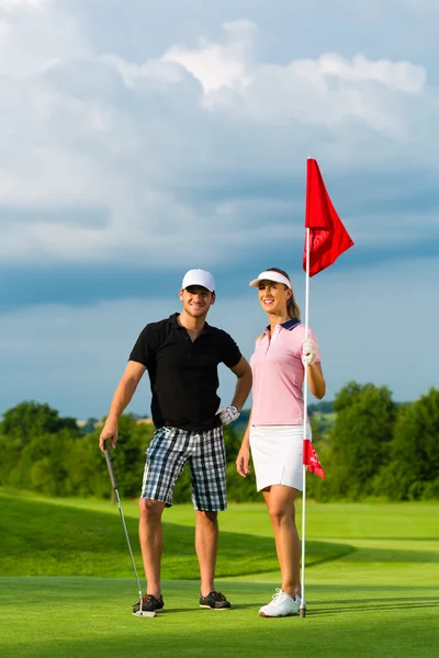 Молодая спортивная пара играет в гольф на поле — стоковое фото
