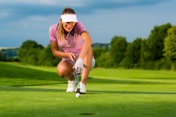 Giovane giocatore di golf femminile in corso puntando per lei mettere — Foto Stock