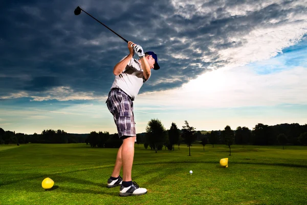 Young golf player on course doing golf swing — Stock Photo, Image