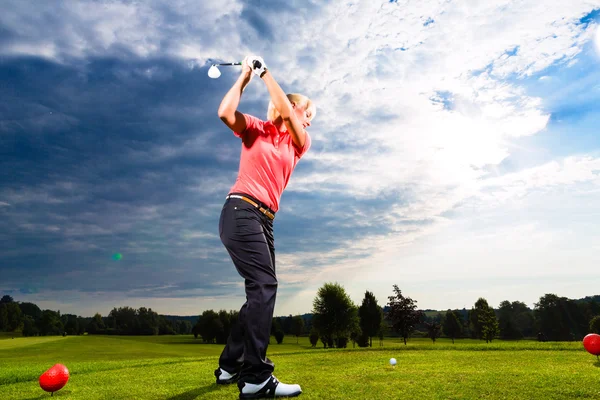 Jugador de golf joven en curso haciendo swing de golf — Foto de Stock
