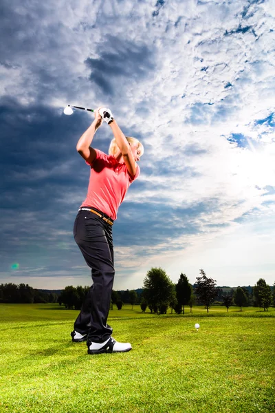 Jovem jogador de golfe em curso fazendo balanço de golfe — Fotografia de Stock