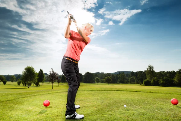 Young golf player on course doing golf swing — Stock Photo, Image