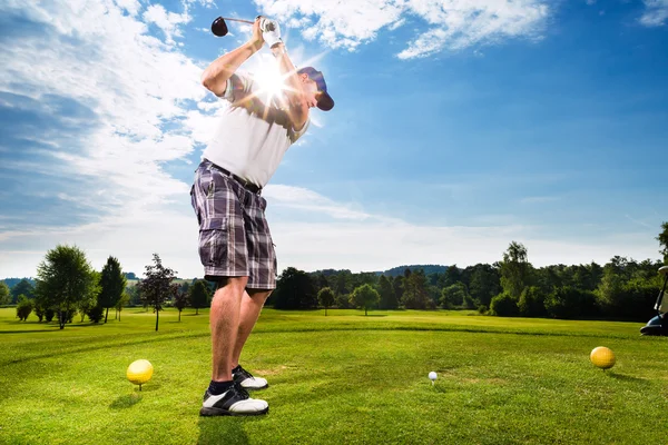 Young golf player on course doing golf swing — Stock Photo, Image