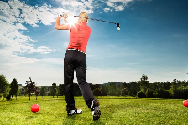 Young golf player on course doing golf swing — Stock Photo, Image