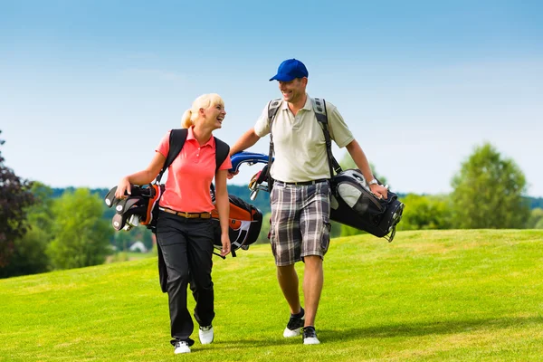 Молодая спортивная пара играет в гольф на поле — стоковое фото