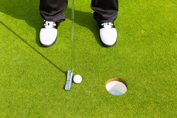 Jugador de golf poniendo pelota en el agujero — Foto de Stock