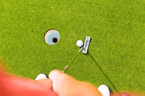 Jogador de golfe colocando bola no buraco — Fotografia de Stock