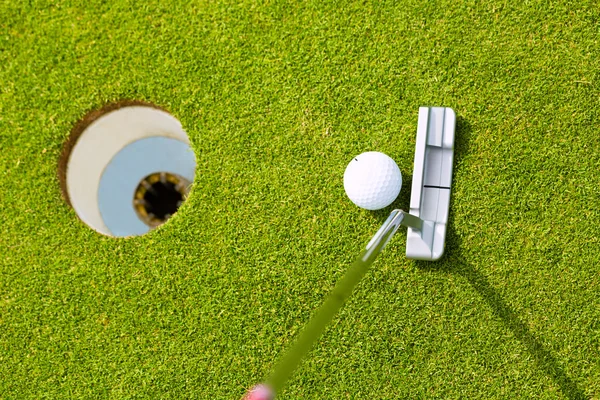 Jogador de golfe colocando bola no buraco — Fotografia de Stock