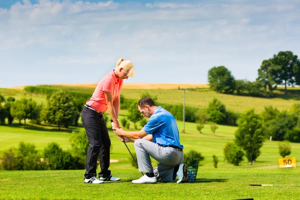 Молода жінка грає в гольф на курсі — стокове фото