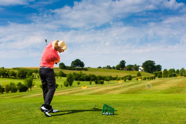 Молода жінка гольфіст на драйвінг рейндж — стокове фото