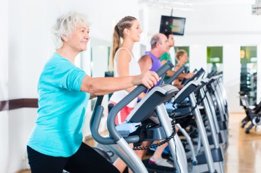 Bir grup insan üzerinde eliptik eğitmen spor salonunda egzersiz