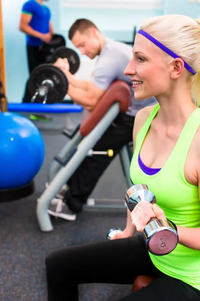 Vrouw in gym training bij stom klokken — Stockfoto