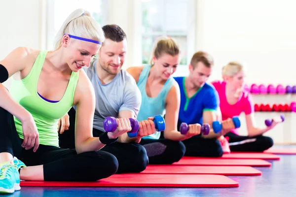 Fitness människor i gymmet träna med hantlar — Stockfoto