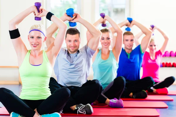 Persone in palestra che si allenano con i manubri — Foto Stock