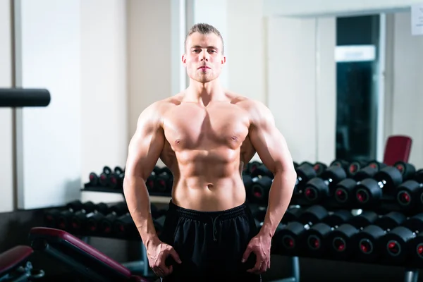 Kroppsbyggare poserar i gymmet — Stockfoto