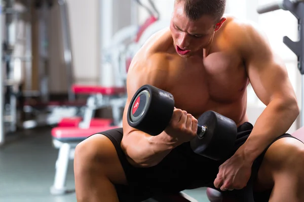 Homem em Dumbbell formação em ginásio — Fotografia de Stock